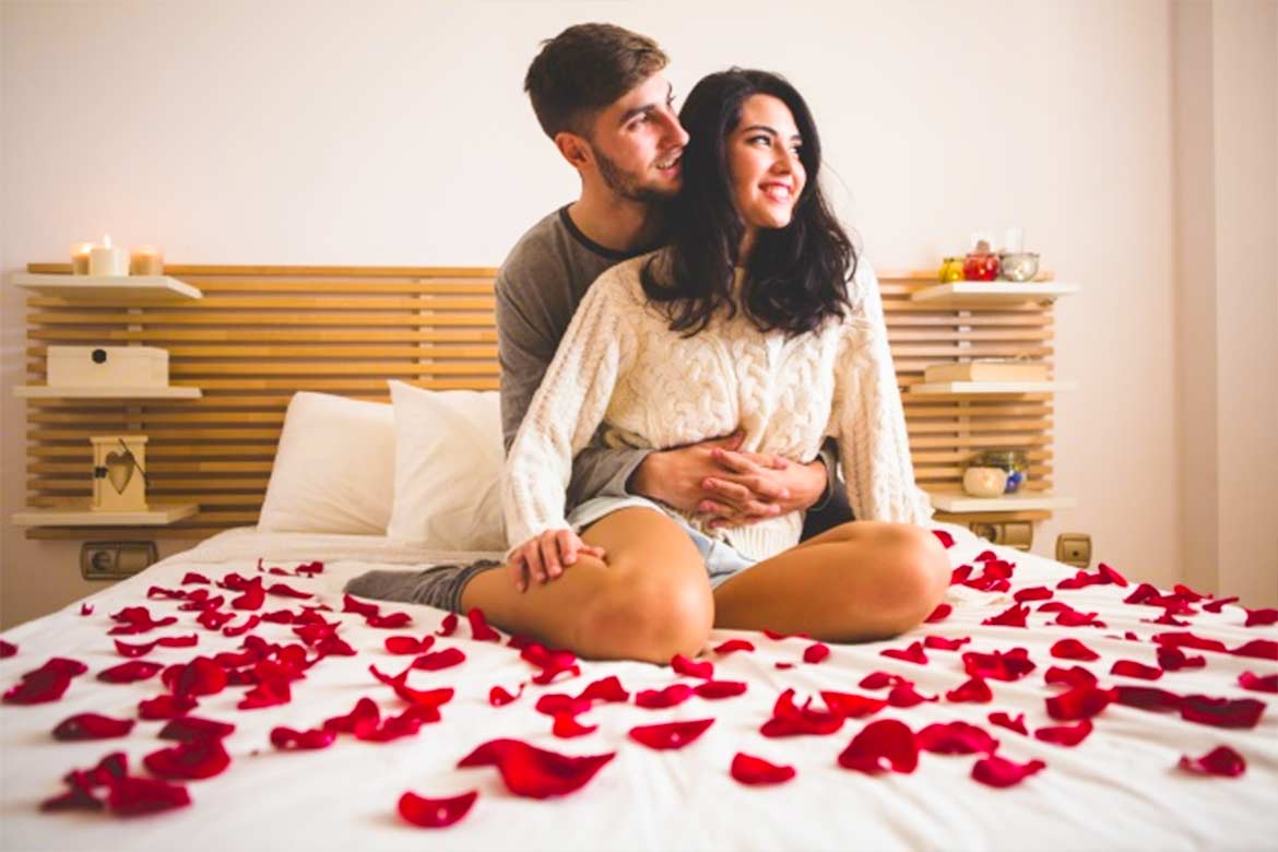 Влюбленные романтично занимаются любовью на красном диване 